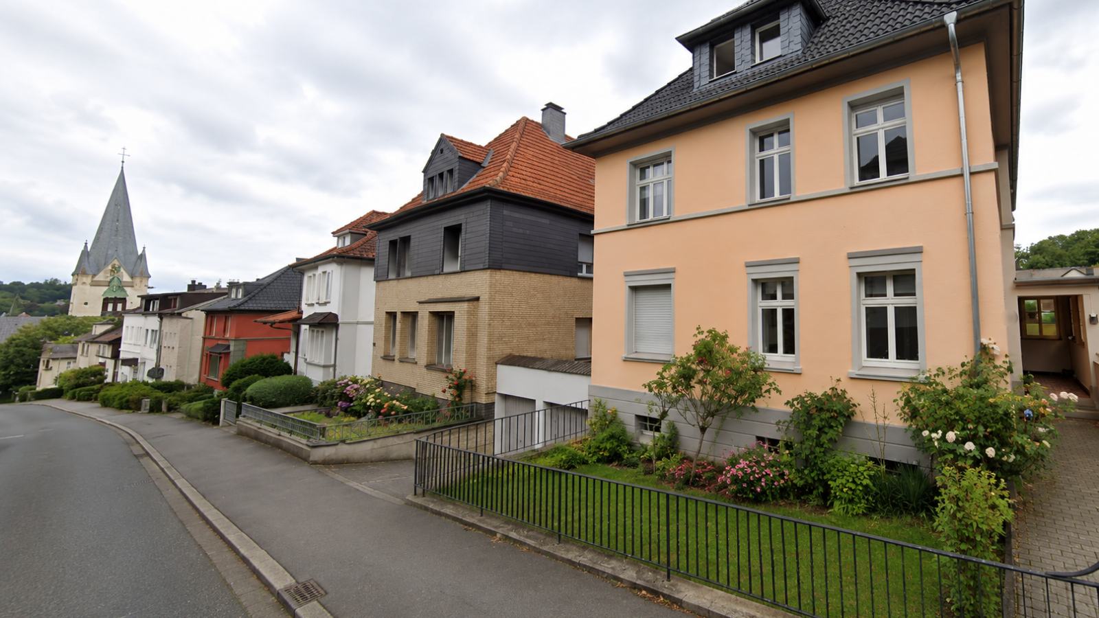 Wohnstraße in Menden mit Altbauten und Blick zur Pfarrkirche