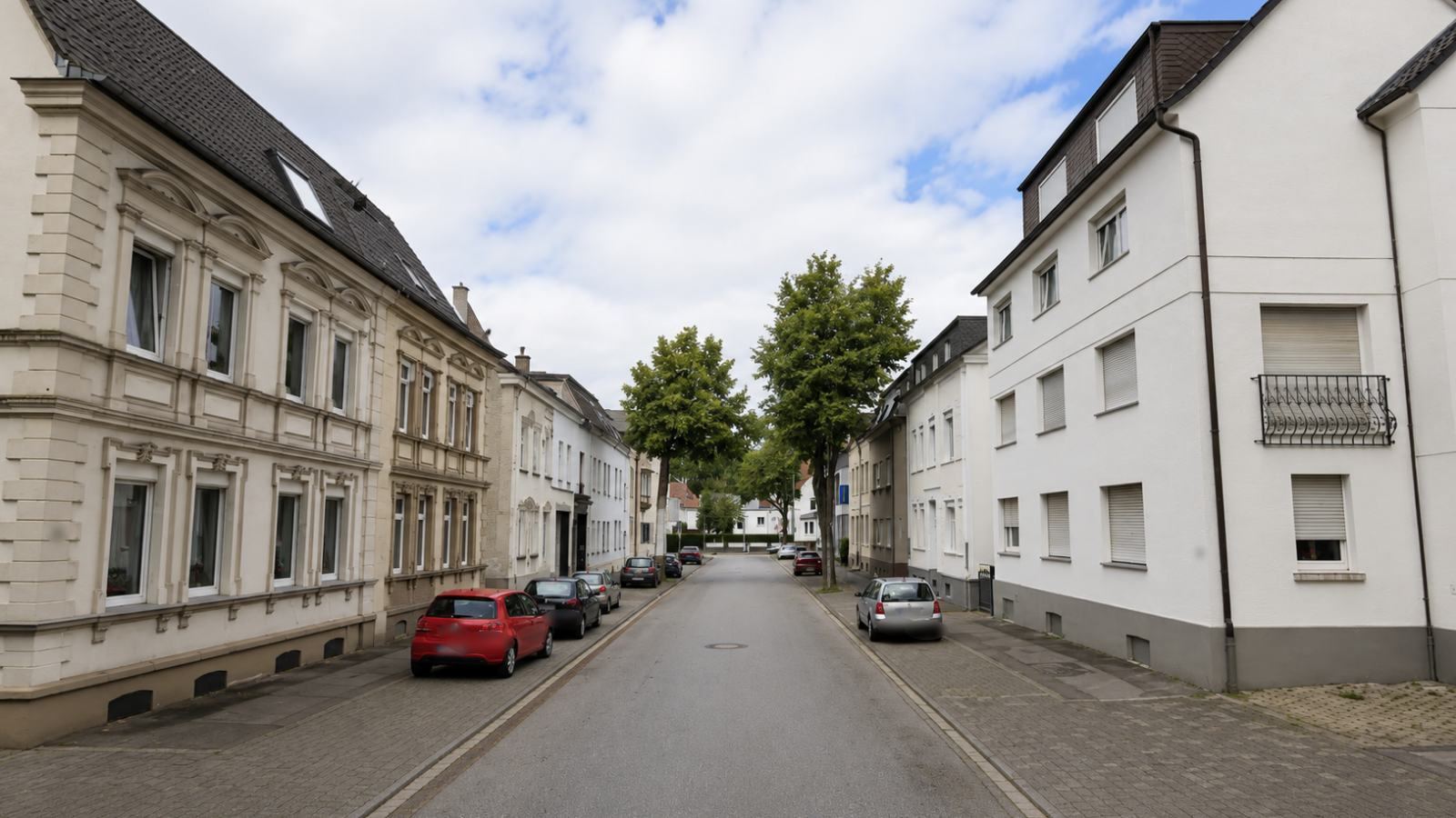 Straßenzug in Menden mit Mehrfamilienhäusern und Stuckfassaden